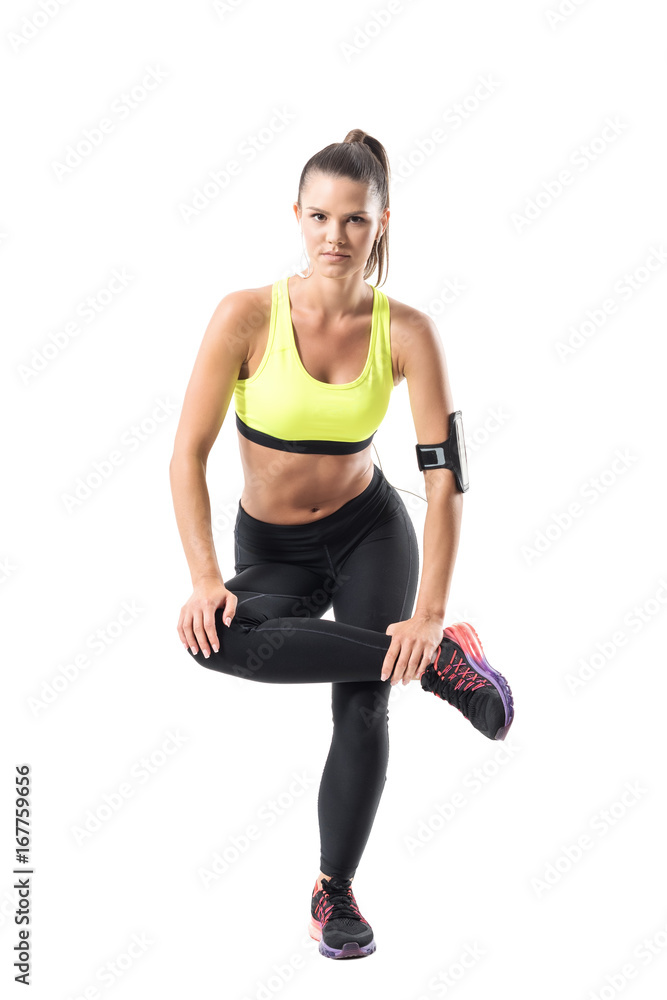 Fit pretty female athlete lifting on single leg doing squat exercise. Full body length portrait isolated on white studio background Fit pretty female athlete lifting on single leg doing squat exercise. Full body length portrait isolated on white studio background