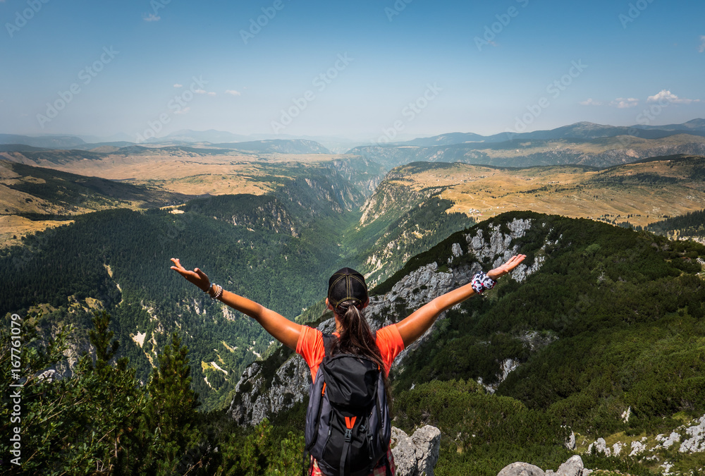 Obraz premium Hiker woman spreading her hands in front of huge river canyon. National Park Durmitor, Montenegro.