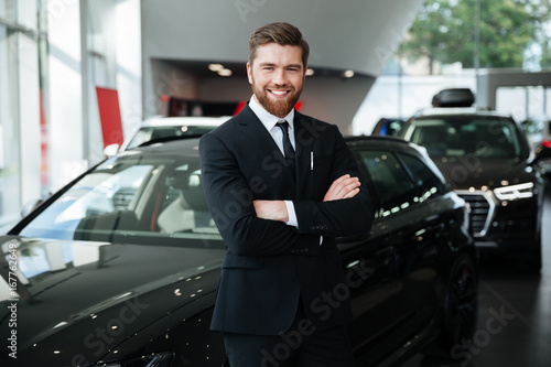 Smiling young male dealer in suit