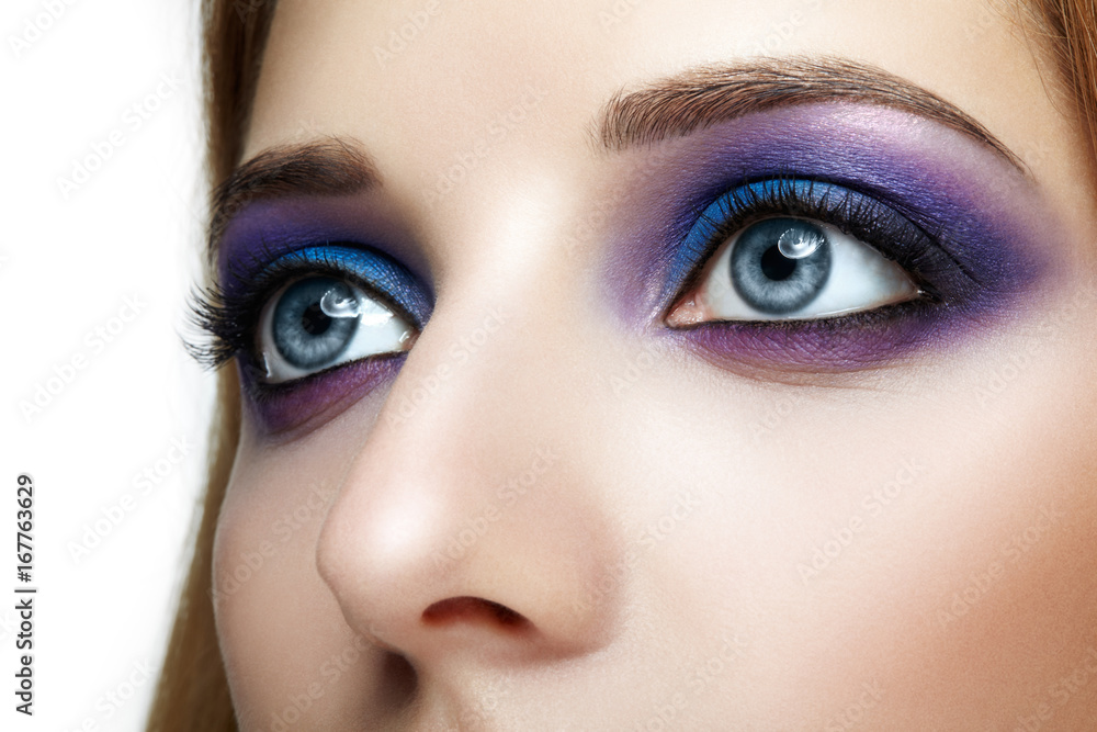 Fototapeta premium Female face eye with blue and violet makeup