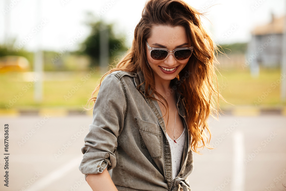 Happy smiling woman in sunglasses having fun outdoors