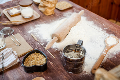 Preparation of the dough. The rolling pin with flour on a wooden table.