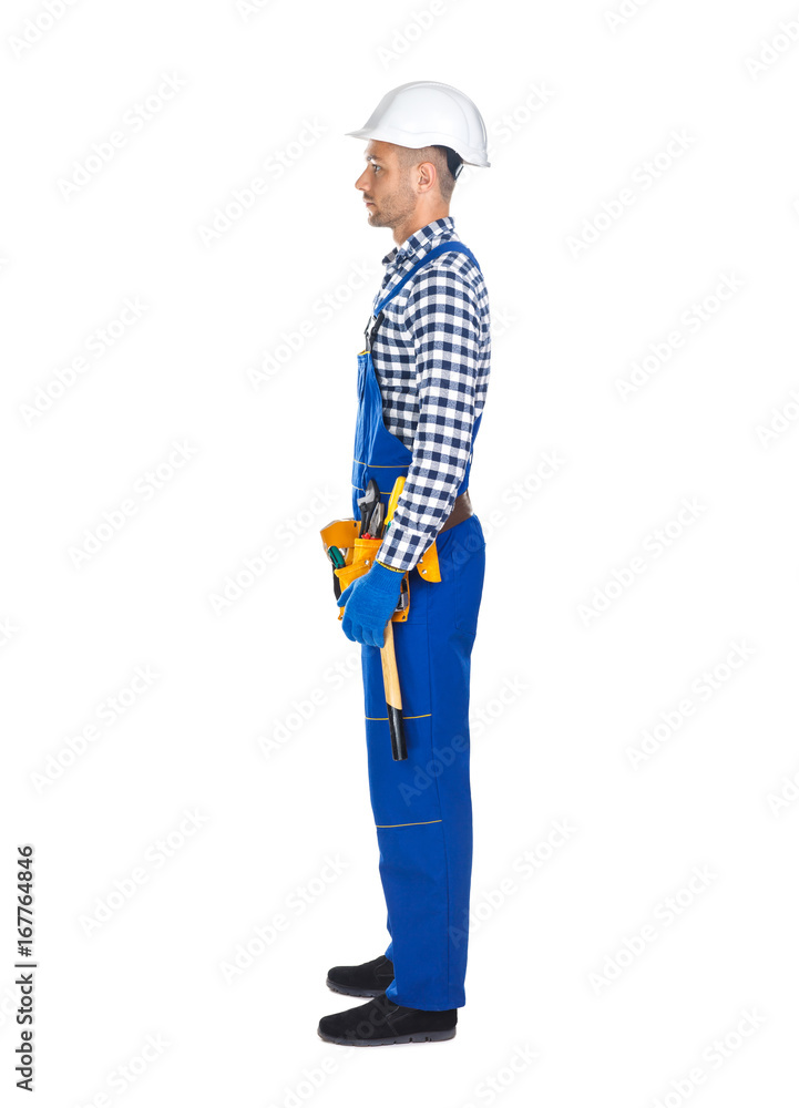 Side view of young construction worker in uniform and tool belt Side view of young construction worker in uniform and tool belt