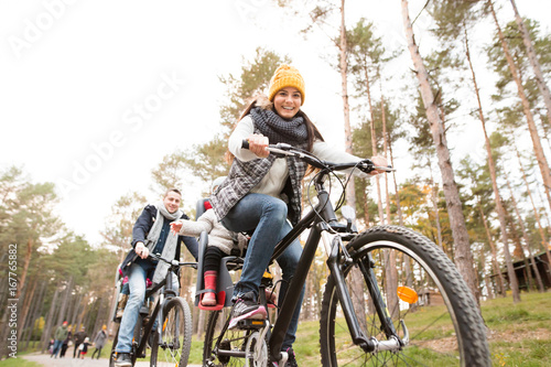 Young family in warm clothes cycling in autumn park © Halfpoint