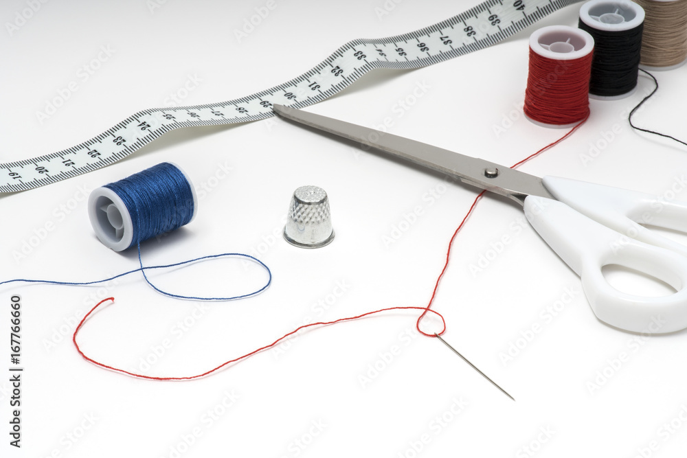 Tailor tools on white table with multiple skeins on both sides Tailor tools on white table with multiple skeins on both sides
