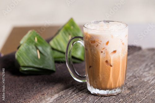 Thai iced tea milk signature local street beverage serve with dessert on wooden table