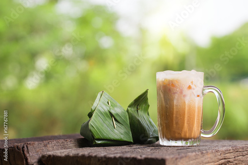 Thai iced tea milk signature local street beverage serve with dessert on wooden table