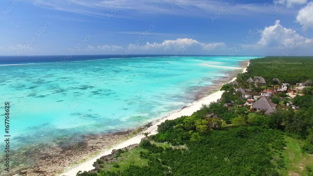 Aerial view of Nungwi, multicolored sea water of blue lagoon, north part of Zanzibar, White beach, Palm paradise, Tanzania from above, Africa, Indian Ocean, 4k UHD Aerial view of Nungwi, multicolored sea water of blue lagoon, north part of Zanzibar, White beach, Palm paradise, Tanzania from above, Africa, Indian Ocean, 4k UHD