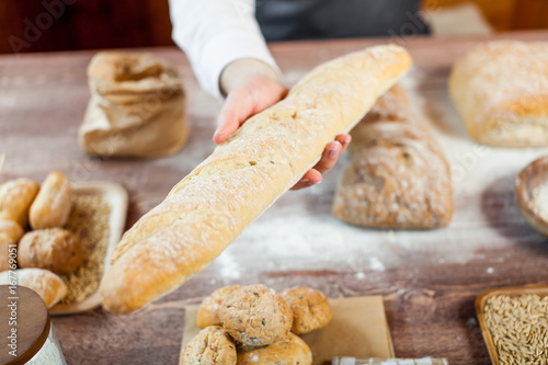 Baker man holding a beautiful fresh bread