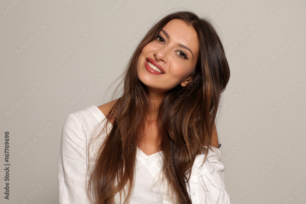 seductive and smiling young woman on a gray background seductive and smiling young woman on a gray background