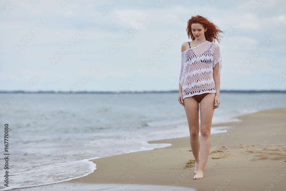 Attractive young redhead woman on a beach Attractive young redhead woman on a beach