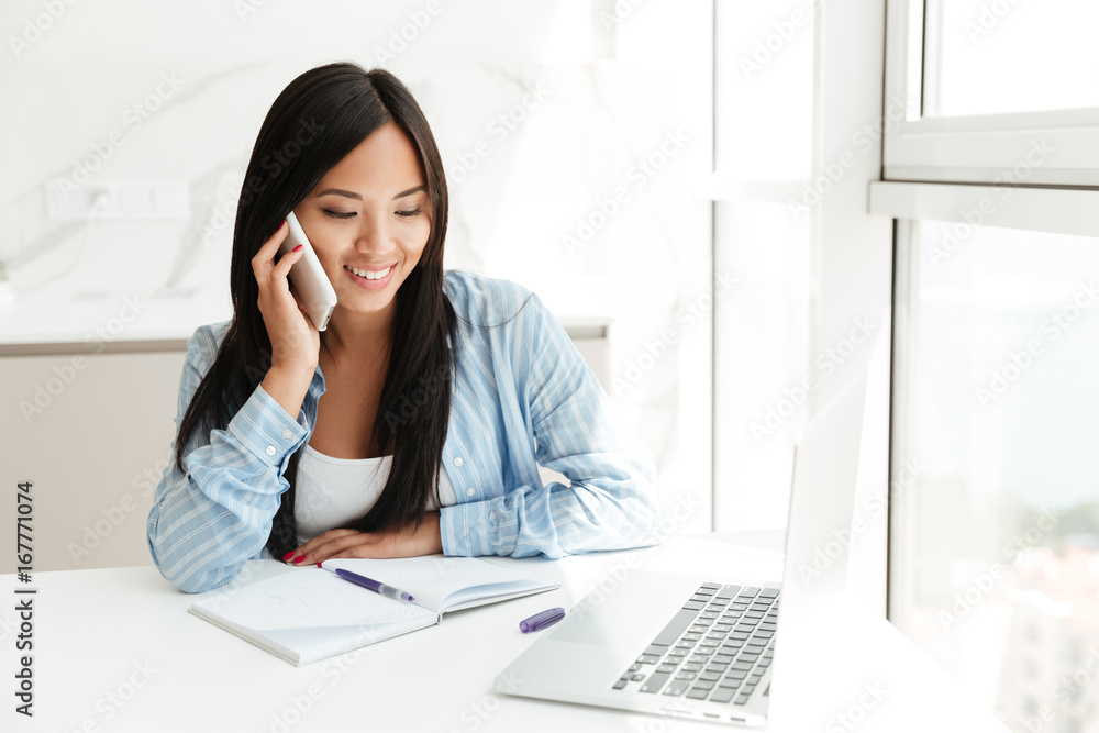 Smiling asian woman talking on mobile phone Smiling asian woman talking on mobile phone