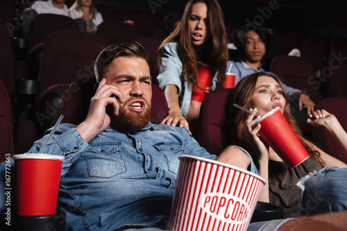 Rude young man talking on mobile phone