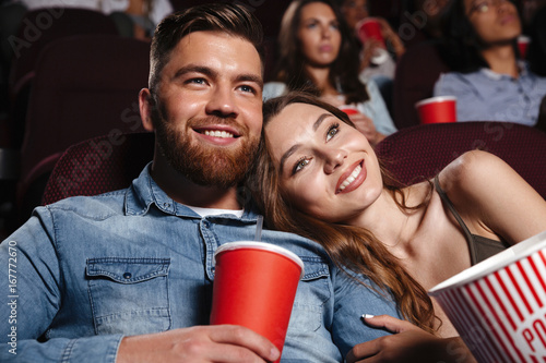Close up of a smiling young couple watching movie