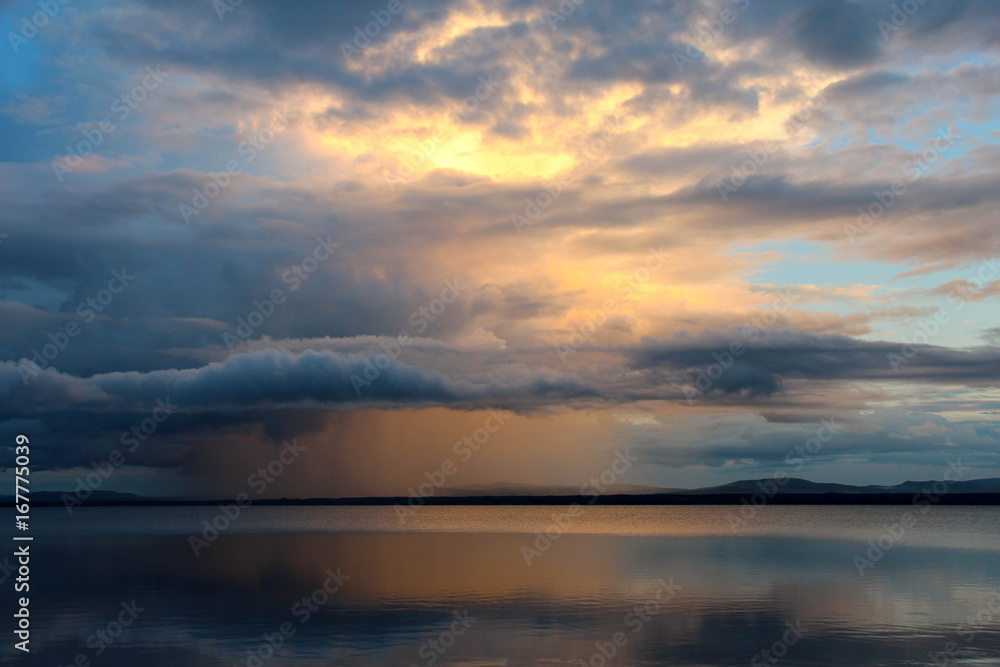 Sunset and rain clouds over Orsa lake, Sweden.