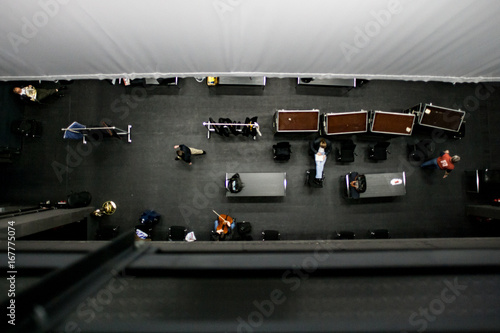 Backstage-Bereich mit Musikern und Flight Cases von oben aus dem Schnürboden eines Theaters - Backstage area with musicians and flight cases from the top of a theatre