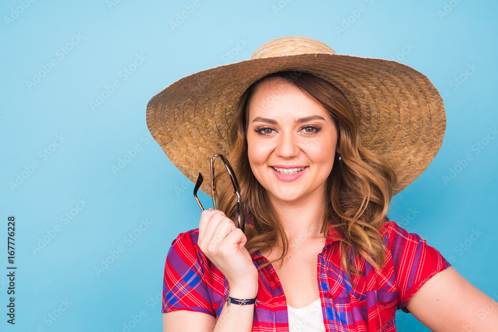 Portrait of beautiful woman in hat on blue background and copy space