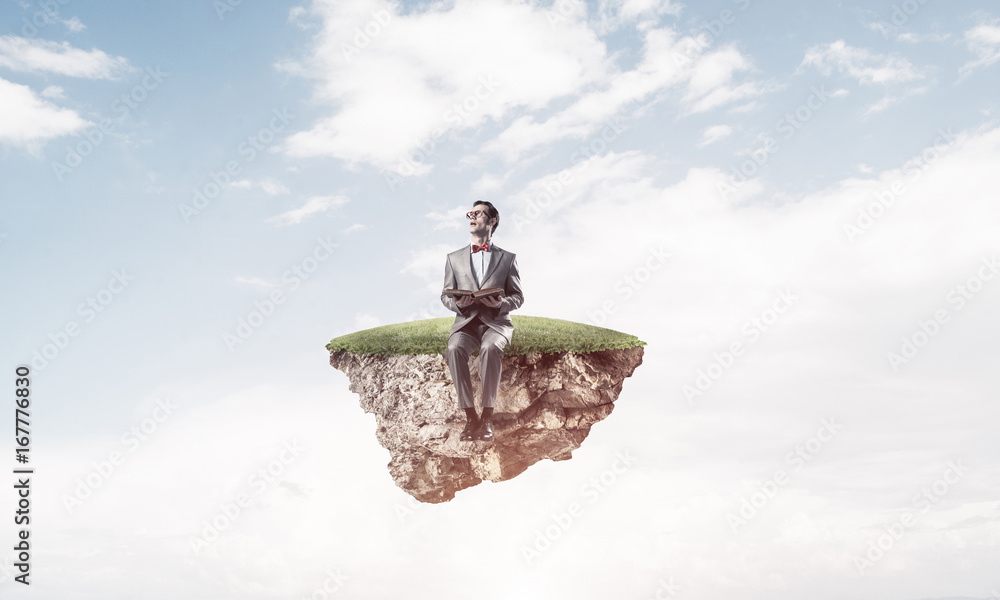 Young businessman or student floating in sky and studying the sc