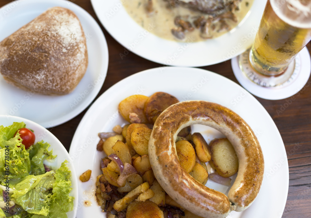 Traditional German meal with sausage, potato and beer Traditional German meal with sausage, potato and beer