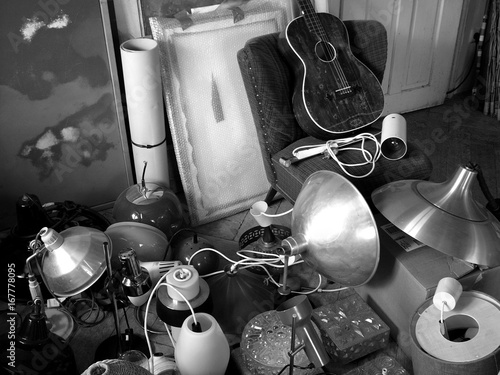 Trödel mit alten Lampen und Gitarre auf dem Dachboden eines Bauernhaus in Rudersau bei Rottenbuch im Kreis Weilheim-Schongau in Oberbayern, fotografiert in neorealistischem Schwarzweiß