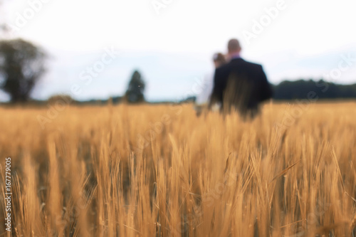 Just married lovers walking in a field in autumn day © alexkich
