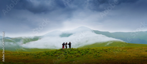 Hiking campers photographing a natural phenomenon - the clouds that roam the mountains. Concept theme: nature, weather, tourism, extreme, healthy lifestyle, adventures. Unrecognizable persones. © Sodel Vladyslav