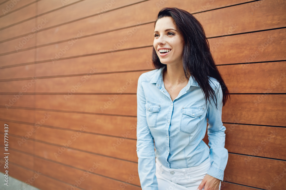 Beautiful smiling girl on the background of a wooden wall Beautiful smiling girl on the background of a wooden wall
