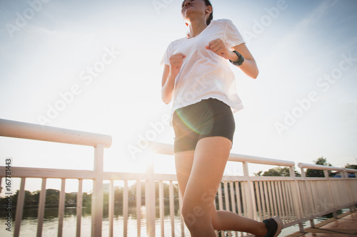 Healthy woman running and jogging on bridge at morning 