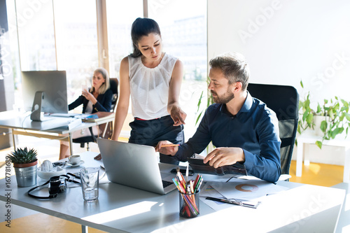 Three business people in the office working together. photo