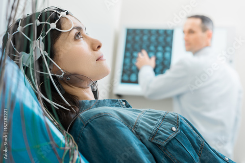 Charming young woman undergoing electroencephalography photo