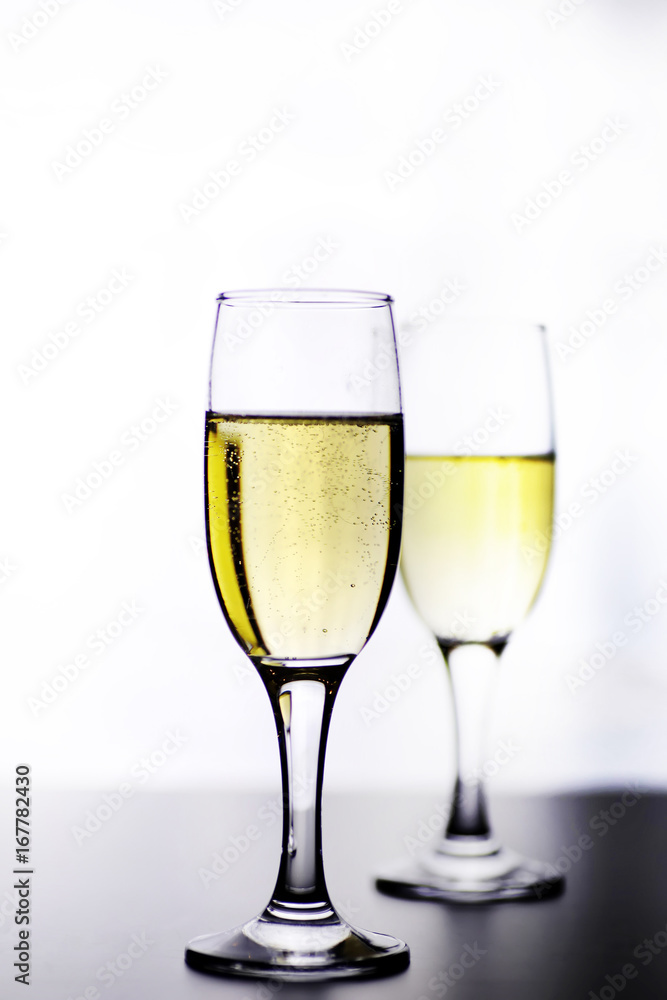 glass of white wine on a table on white background isolate glass of white wine on a table on white background isolate
