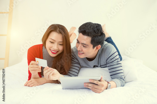 Asian young couple shopping online at home