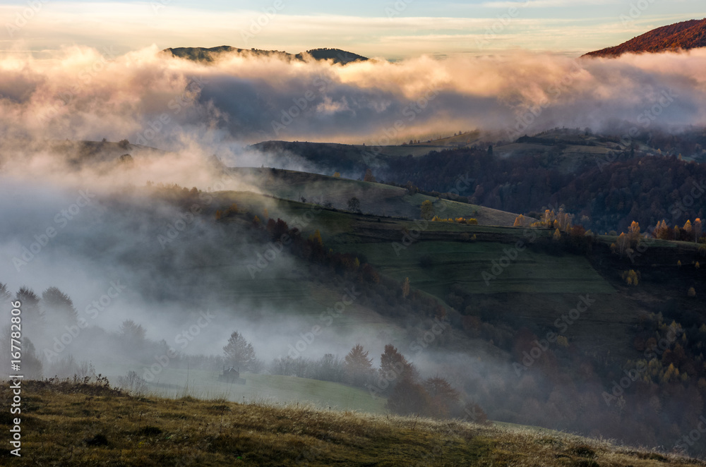 thick fog on hills in countryside at sunrise