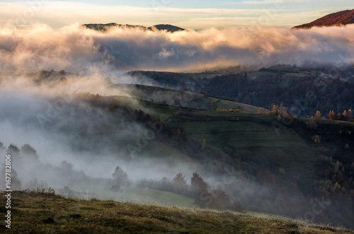 thick fog on hills in countryside at sunrise