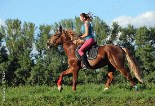 Young female riding on saddle horse