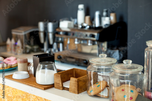 Bar counter with biscuits, donuts and sugar in the coffee house, against the background of the coffee machine photo