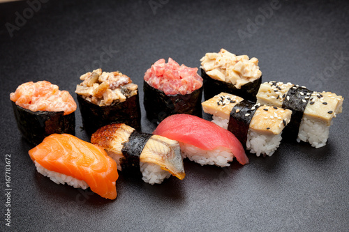 Obraz na plátně Many different sushi on a black table, Japanese food