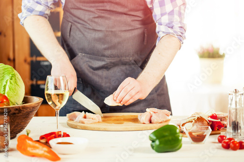 male preparing chicken for cooking