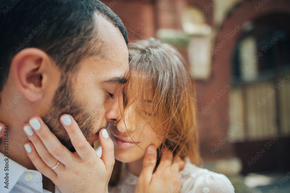 Fototapeta premium beautiful wedding couple hugging standing near old building