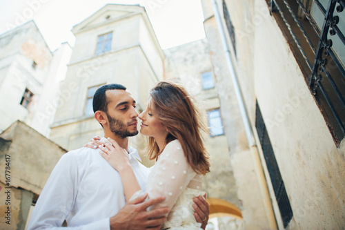 portrait of beautiful bride hugging her handsome groom outdoors