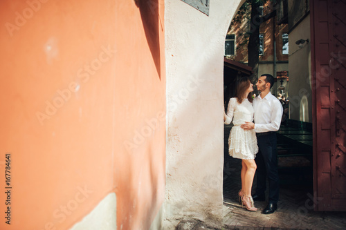 portrait of beautiful bride hugging her handsome groom outdoors