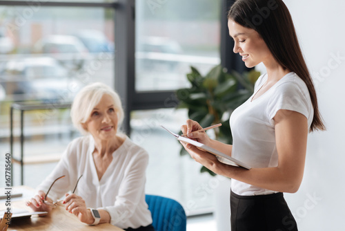 Joyful positive woman taking notes