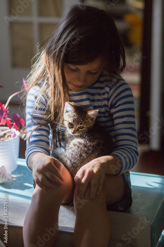 Girl with kitten sitting on lap photo