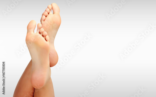 Beautiful woman's bare feet against a grey background with copyspace photo