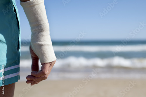 man on the beach with a bandage in his wrist photo