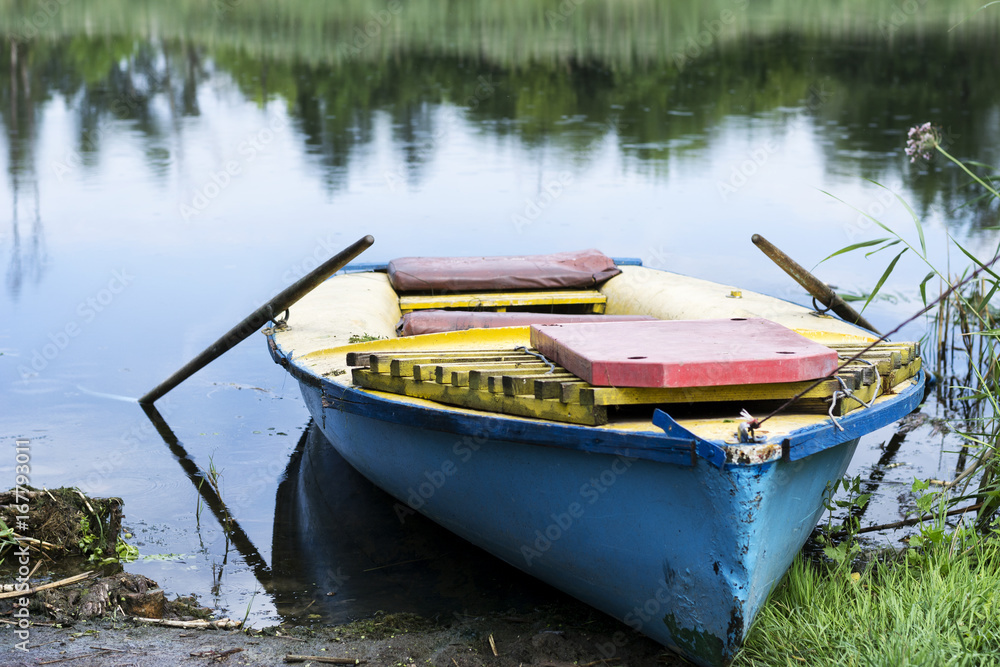 Obraz premium An old boat on the river bank. Summer sunny day.