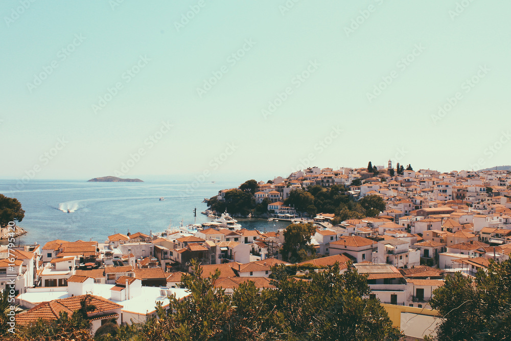 Skyathos panorama with white houses, ships on the sea and small pedestrian streets