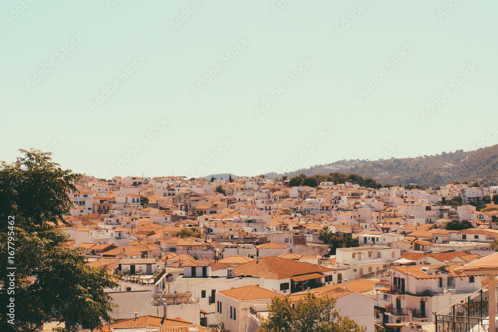 Greek island town with traditional architecture, typical white houses with red tile roofs.