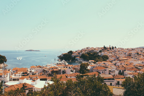 Skyathos panorama with white houses, ships on the sea and small pedestrian streets