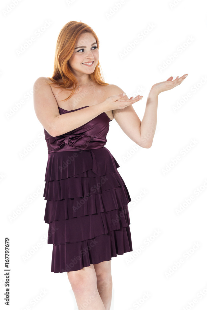 Girl presents with two hands local to advertising space. Redheaded girl wearing dark purple strapless dress. Girl presents with two hands local to advertising space. Redheaded girl wearing dark purple strapless dress.